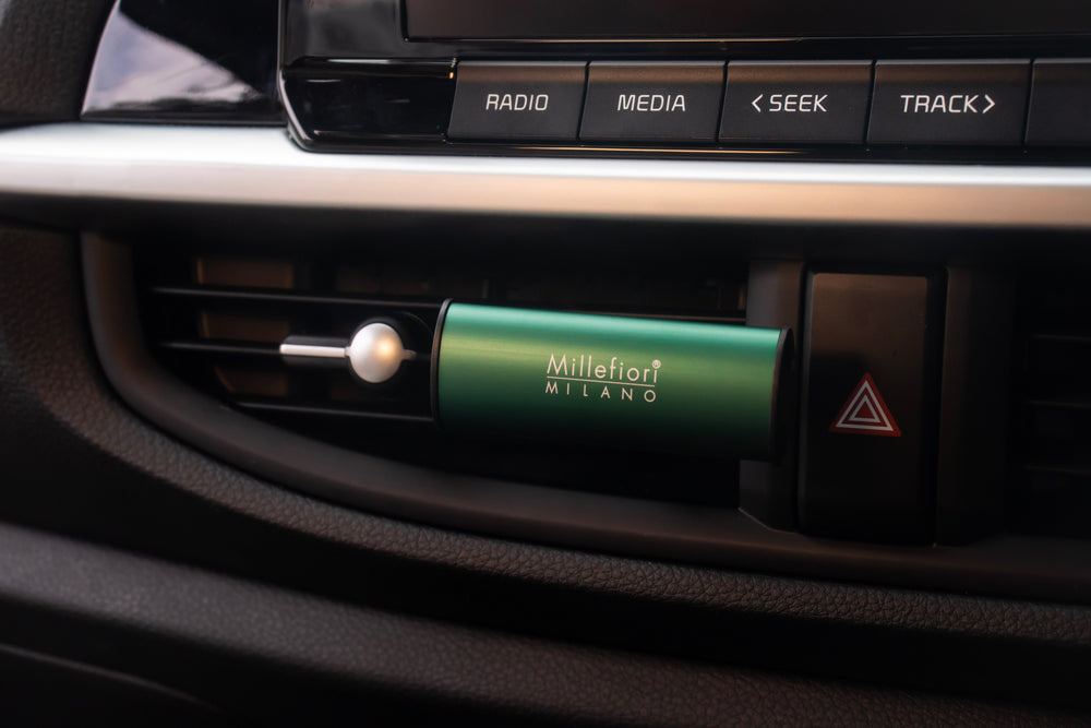 Car air freshener with 'Millefiori Milano' branding in a car's air vent.